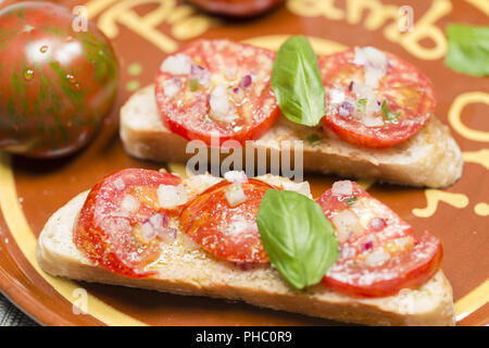 Avec pain de campagne tomates zebra noir et d'huile d'olive Banque D'Images