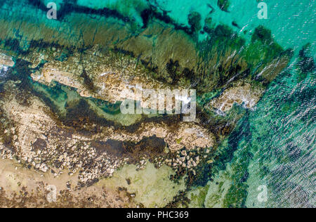 Une photo aérienne d'une plage de sable, rochers et mer turquoise des vagues de l'eau Banque D'Images