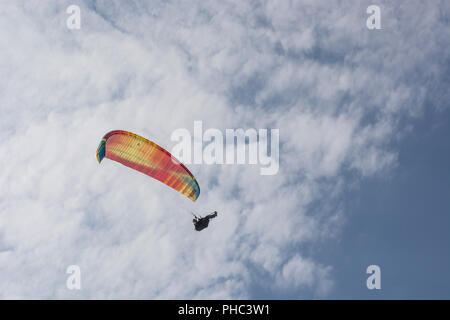 Parapentiste vole dans le ciel d'été bleu Banque D'Images