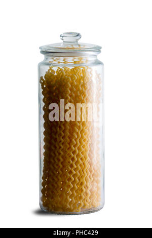 Fusilli bucati lunghi frais secs pâtes spirales stockés dans un grand cartouche en verre clair isolé sur blanc dans une vue en gros plan Banque D'Images