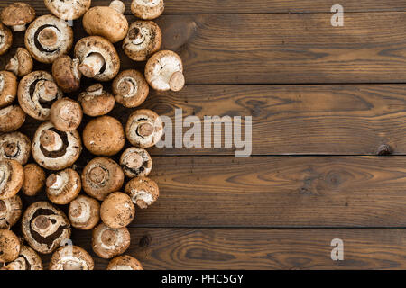 La frontière du côté de matières premières fraîches Bella Bébé ou Agaricus bisporus champignons sur un fond de bois rustique with copy space Banque D'Images