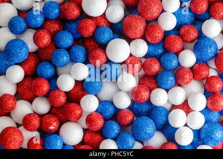 Rouge Blanc et bleu paillettes décoratives boules dans un mix aléatoire formant un abrégé américain patriote ou motif de fond britannique Banque D'Images