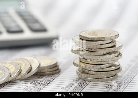 Les pièces en euros empilés avec des données et tableau des marchés de change Banque D'Images