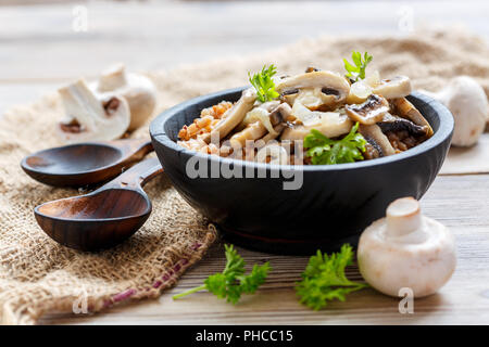 La bouillie de sarrasin aux champignons et oignons dans un bol en bois. Banque D'Images