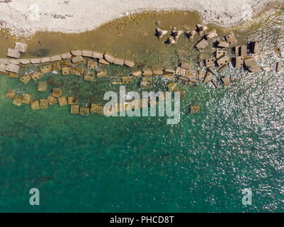 Les blocs de béton et les tétrapodes sur la rive de la mer turquoise. Haut de page vue aérienne faite par drone Banque D'Images