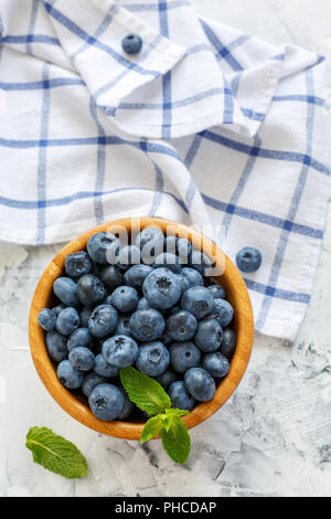 Les bleuets et les feuilles de menthe dans un bol en bois. Banque D'Images