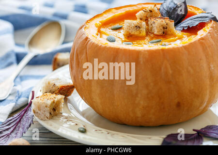 Soupe au potiron avec des croûtons dans un gros plan de la citrouille. Banque D'Images