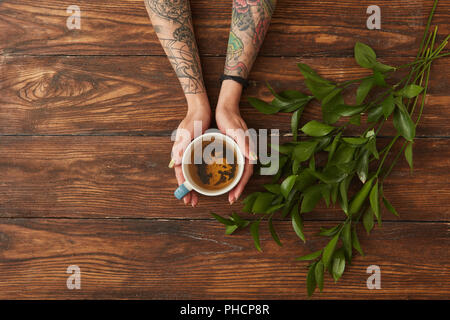 Les mains tenant un plateau tasse Banque D'Images