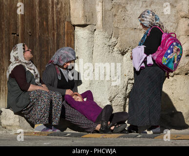 Trois femmes musulmanes dans un hijab et une fille se détendre et parler dans le soleil du matin à Göreme, Turquie Banque D'Images