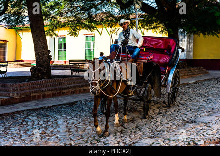 Cowboy cubain prend les rênes du Cheval et buggy sur une rue pavée de Trinidad, Cuba. Banque D'Images