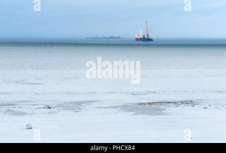 Boues de glace dans la mer d'huile, plate-forme dans la mer d'hiver à l'horizon Banque D'Images