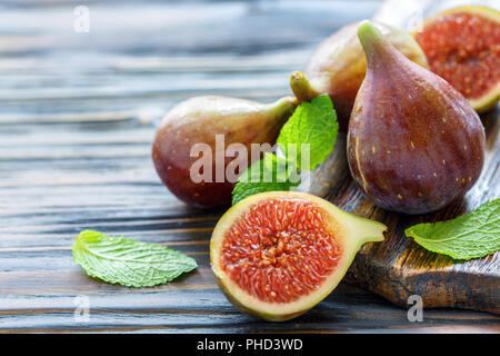 La moitié des figues douces mûres et les fruits entiers. Banque D'Images