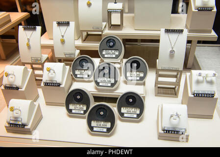 Diamants ronds de tailles différentes, les bagues et colliers afficher dans un magasin de détail de luxe vitrine vitrine à Hong Kong Banque D'Images