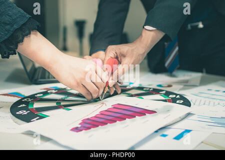 Stratégie et concept cible,close up hands de gens d'affaires groupe mettre fléchettes sur l'objectif de la planification et du conseil à la réalisation en salle de réunion. Banque D'Images