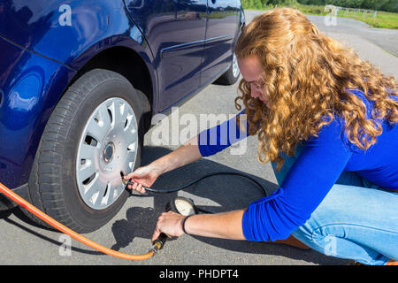 Contrôle de pression d'air de fille des pneus de voiture Banque D'Images