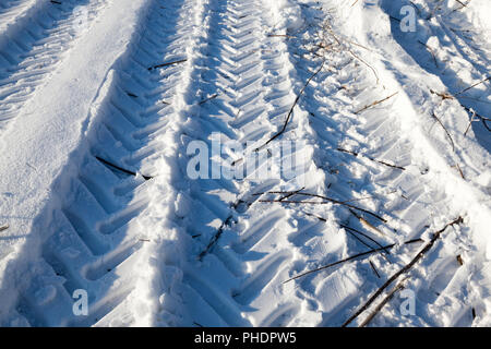 Des traces de roues et le protecteur de transport de grande capacité de cross-country sur neige profonde dans le champ, gros plan Banque D'Images