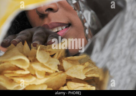 Woman eating potato chips Banque D'Images