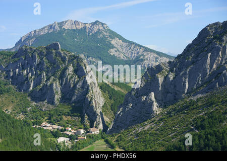 VUE AÉRIENNE. Hameau isolé entouré d'un paysage accidenté. Sigottier, Hautes-Alpes, Provence, France. Banque D'Images