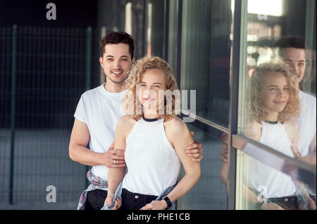 Happy friends embrassant tout en se tenant sur la place de la ville Banque D'Images