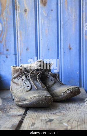 Chaussures usées ancienne sur un plancher de bois Banque D'Images