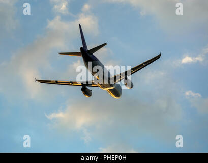 Avion dans les nuages au coucher du soleil Banque D'Images