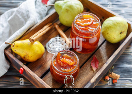 Confiture de poires dans des bocaux en verre et poire fraîche. Banque D'Images