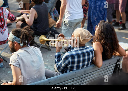 Montréal, Canada - juin 2018. African American male assis sur un banc, et soufflant de la trompette à Tam Tams festival dans le parc du Mont-Royal, Montréal, Canada Banque D'Images