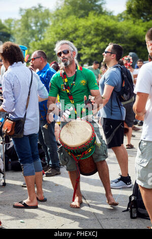 Homme de race blanche percussionniste jouant un rythme avec son djembe bongo dans la foule au festival Tam Tams au parc du Mont-Royal, Montréal, Québec, Canada Banque D'Images