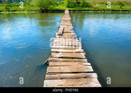 Vieux pont en bois à travers la rivière Banque D'Images