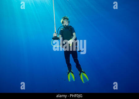 Un plongeur (MR) en photo accrochés sur une ligne à 15 pieds pour un arrêt de décompression avant de surfaçage, Hawaii. Banque D'Images