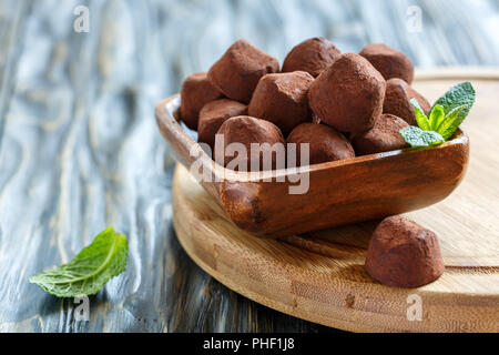 Truffes au chocolat noir faites maison dans un bol en bois. Banque D'Images