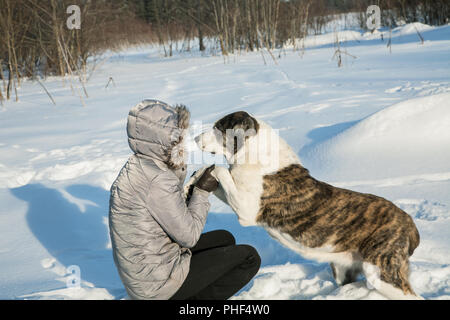 Femme joue avec un chien dans l'après-midi d'hiver Banque D'Images