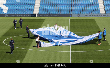 Brighton & Hove Albion joueurs sur le terrain comme des mises à l'écusson de club sur le cercle central avant le premier match de championnat au stade AMEX, Brighton. Banque D'Images