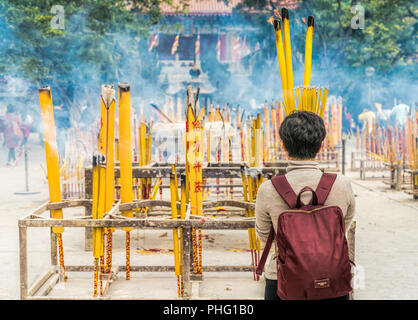 19 février 2018 - L'île de Lantau, à Hong Kong. Femme en prière avec du jaune d'encens brûlant au monastère Po Lin, situé dans l'île de Lantau, Honkg Kon Banque D'Images