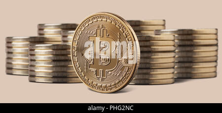 Seule Pièce de bitcoin debout devant des piles de pièces de monnaie Banque D'Images
