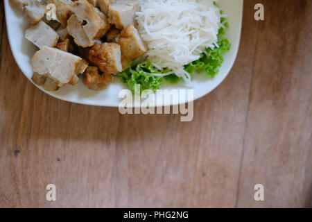 Saucisse de porc haché, de nouilles de riz fermenté et de légumes servi avec la sauce chili. d'été vietnamiens de l'alimentation rouleau appelé Nem Nuong Xa Banque D'Images