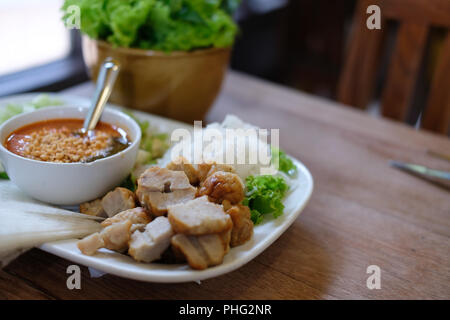 Saucisse de porc haché, de nouilles de riz fermenté et de légumes servi avec la sauce chili. d'été vietnamiens de l'alimentation rouleau appelé Nem Nuong Xa Banque D'Images