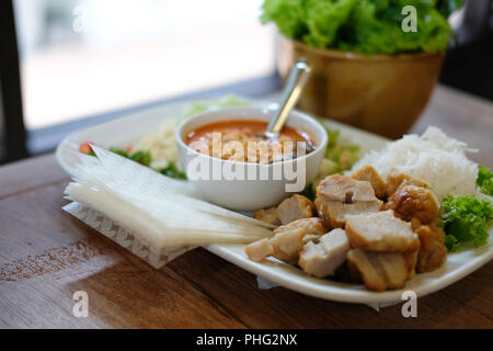 Saucisse de porc haché, de nouilles de riz fermenté et de légumes servi avec la sauce chili. d'été vietnamiens de l'alimentation rouleau appelé Nem Nuong Xa Banque D'Images