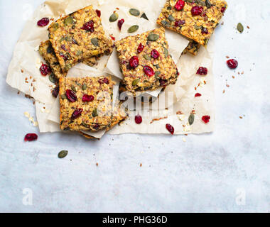 Barres granola, Maison saine, Snack Bars Superfood avec Canneberge, graines de citrouille, d'avoine, graines de lin et de Chia sur fond lumineux, repas vegan Banque D'Images