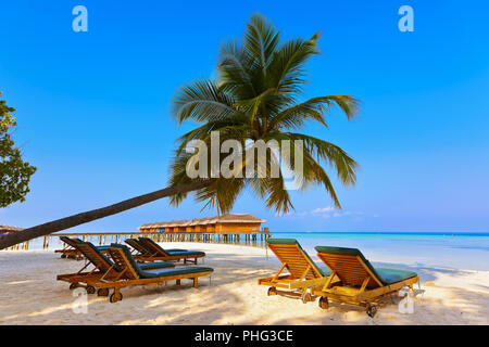 Des chaises longues sur la plage aux Maldives Banque D'Images