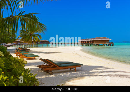 Des chaises longues sur la plage aux Maldives Banque D'Images