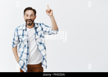 Idée juste moi, avc l'écouter. Portrait de heureux heureux bon-à'homme en chemise à carreaux sur t-shirt, sensibilisation, l'index pointant vers le haut ou en faisant le geste d'eureka avec large sourire satisfait Banque D'Images