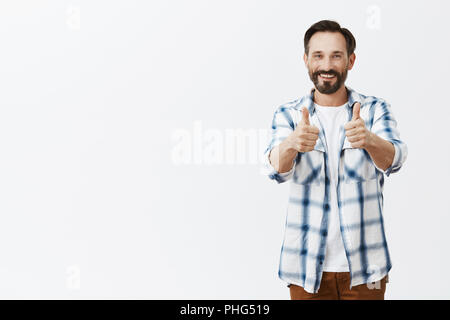 Beau travail fils, fiers de vous. Portrait de vieil homme heureux et satisfait avec la barbe en vêtements décontractés, showing Thumbs up, goût nouveau canapé femme a acheté, donnant la permission ou accepter quelque chose Banque D'Images