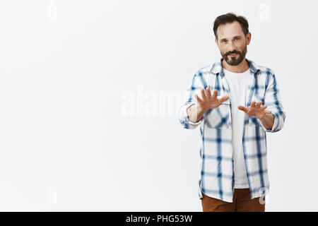 Wow ralentir. Portrait de peur intense et grave beau homme essayant calmer ami qui à propos de faire erreur, debout au-dessus de mur gris avec palmiers, lui demandant d'arrêter sur fond gris Banque D'Images