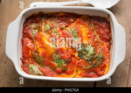 Raviolis à la sauce tomate avec les feuilles d'épinards Banque D'Images