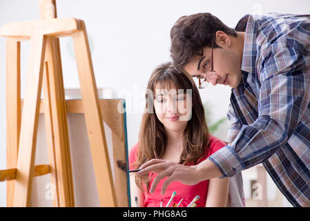 Coaching d'artiste étudiant dans classe de peinture en studio Banque D'Images