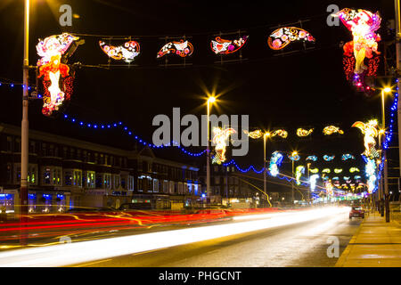 Blackpool, Lancashire, Royaume-Uni. La promenade de nuit, avec une longue exposition de voiture en légèreté, à l'assemblée annuelle de l'Illuminations. Banque D'Images
