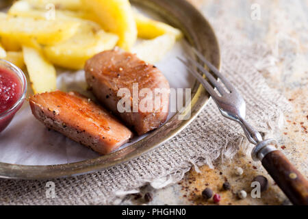 Filet de poisson Thon soutenue avec des pommes de terre sur la plaque sur la pierre Banque D'Images