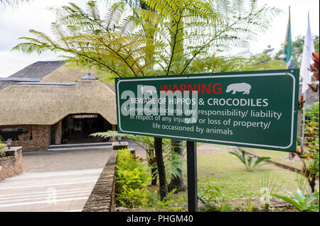 Panneau d'avertissement à l'entrée d'un hôtel en Afrique du Sud montrant la possibilité de rencontrer des animaux dangereux comme les hippopotames et les crocodiles Banque D'Images