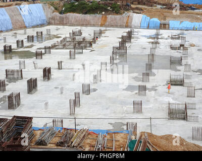 Une antenne de droit de la construction site où la colonne est effectivement fourni sur la dalle pour le prochain niveau. Les travailleurs sont de travailler par étapes. Banque D'Images